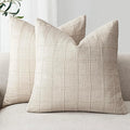 Two beige checkered pillows on a gray sofa with a neutral background