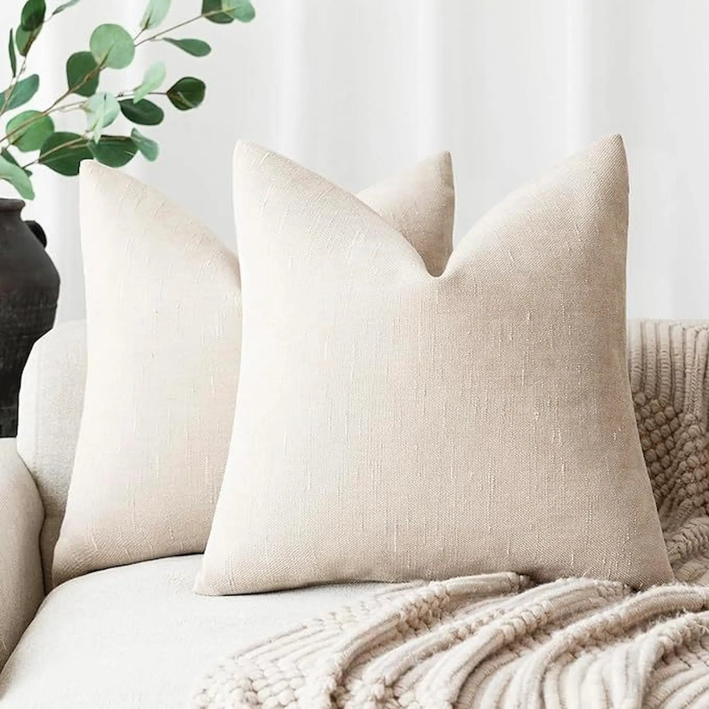 Beige pillows on a sofa with a neutral background