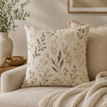 Decorative pillow with floral pattern on a beige sofa in a cozy living room.