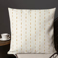 White pillow on a chair with a cup and saucer in the background