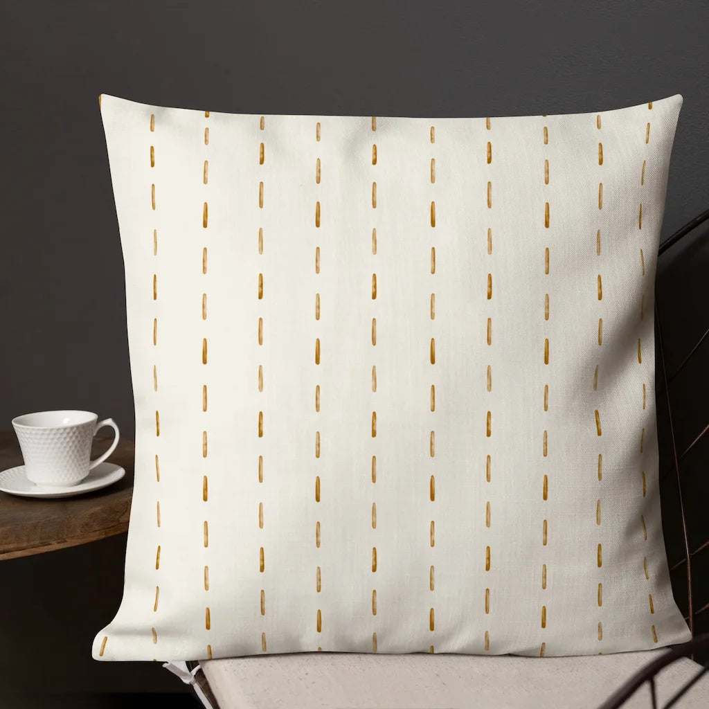 White pillow on a chair with a cup and saucer in the background